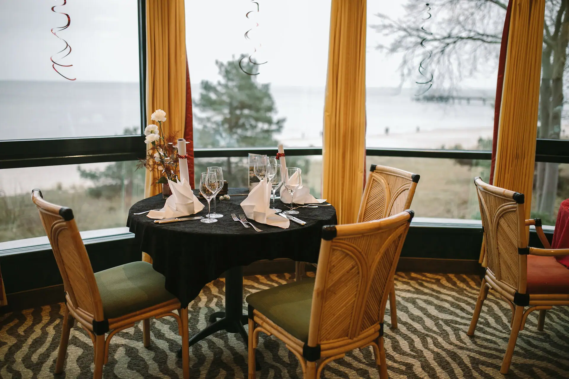 A table with a black tablecloth and a vase of flowers.