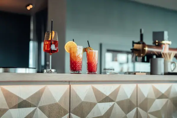 A group of bottles containing various juices on a counter indoors.