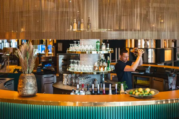 A man pours a drink in a bar.