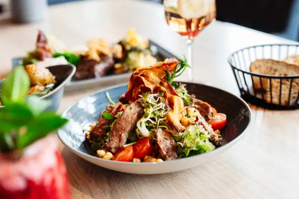 Bowl Ein Teller mit Salat, Fleisch und Gemüse.