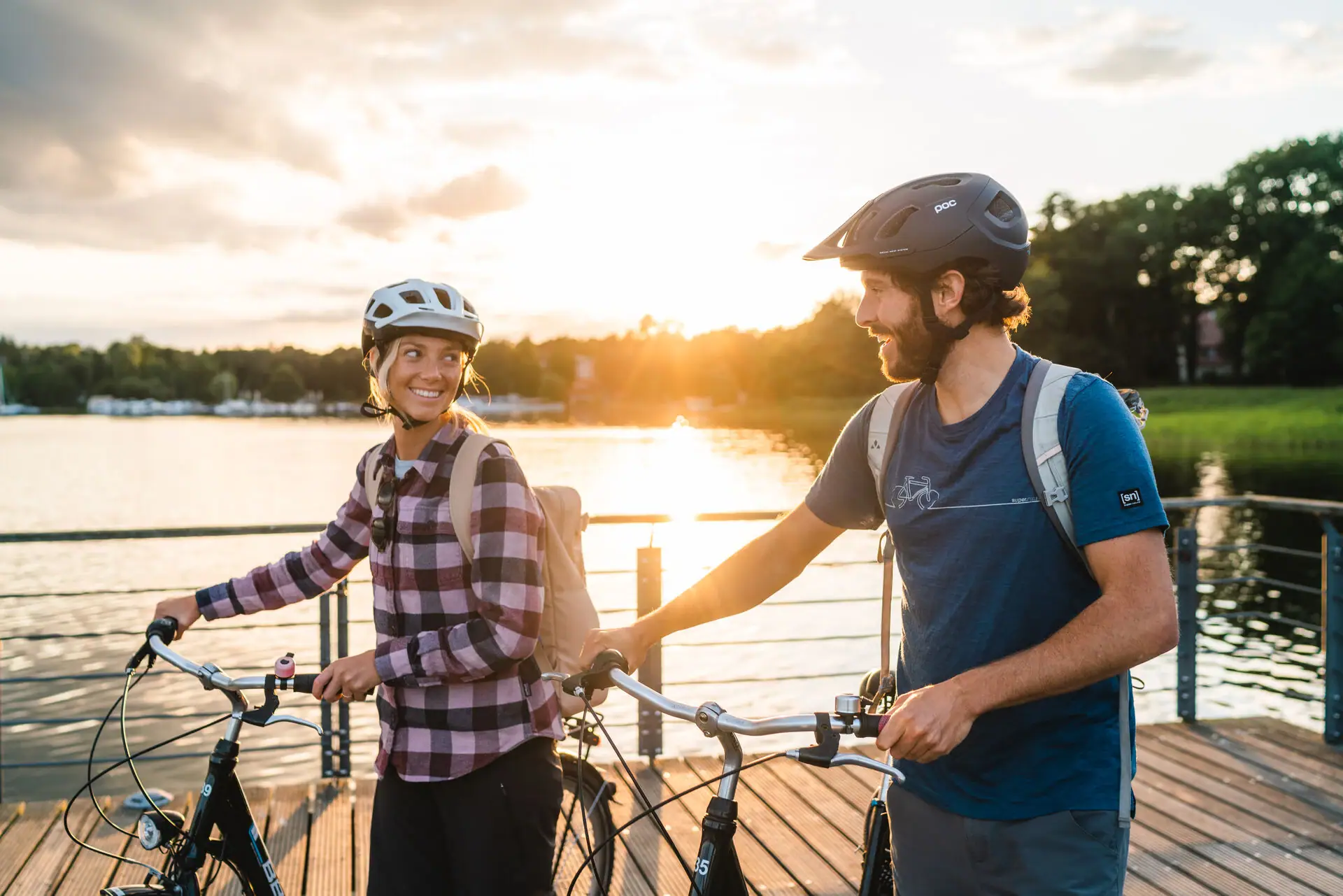 Bike tour in Bad Saarow A man and a woman with helmets and bicycles on a footbridge.
