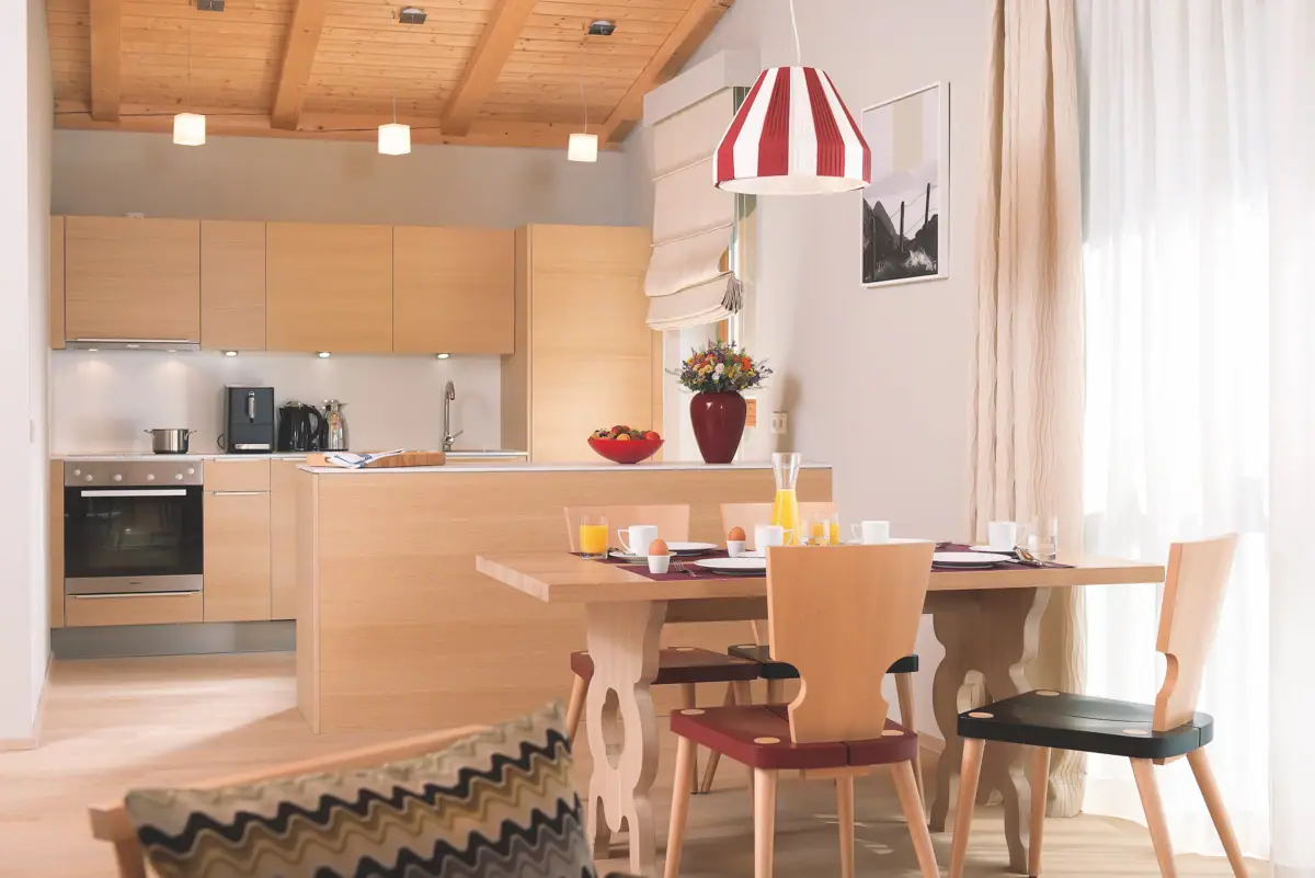 A kitchen with a table and chairs.