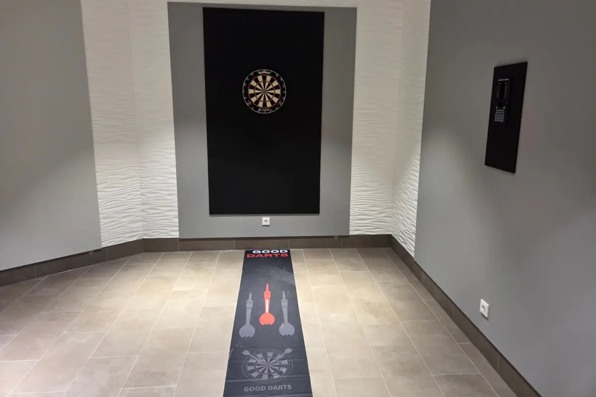 Darts A room with a dartboard and a carpet.
