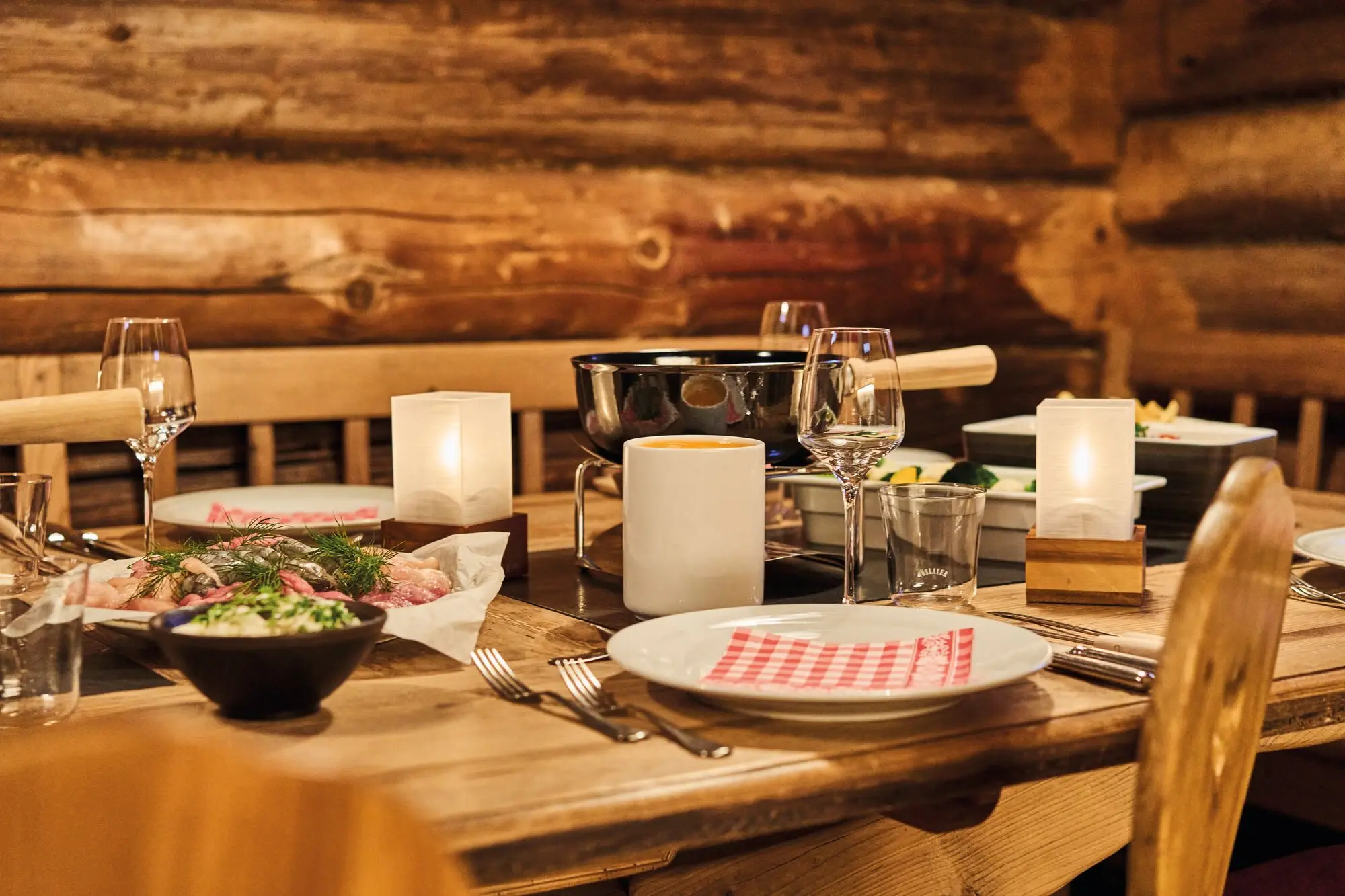 A laid table with food and candles in an interior.