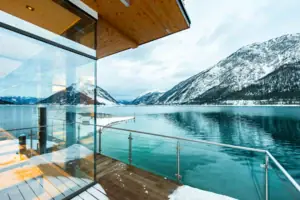 Glaswand und Geländer mit Blick auf einen See