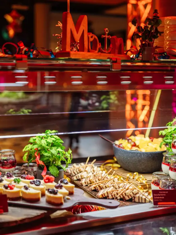 Dessert buffet consisting of cheesecake slices with fruit and a chocolatey cream dessert