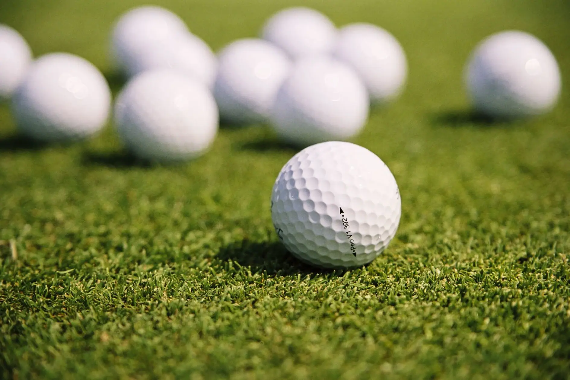 Several golf balls lie on the grass.
