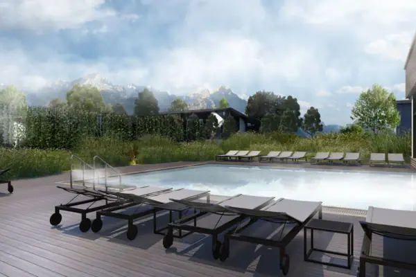 A swimming pool with sun loungers and a house in the background.