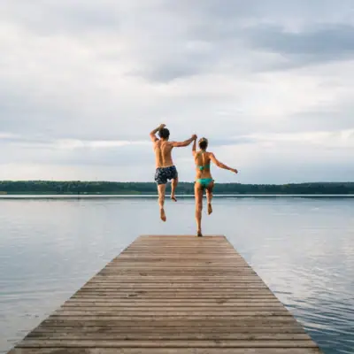 Activities and experiences in Bad Saarow A man and a woman jump into the water.