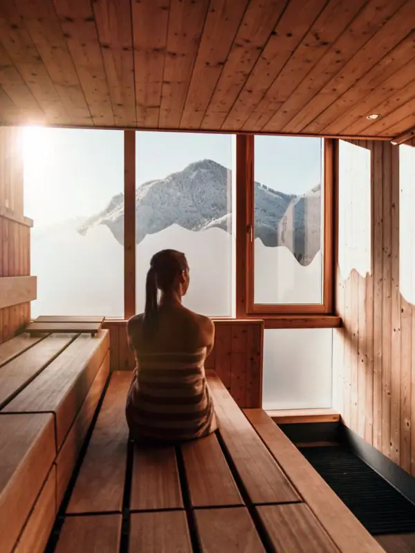 A woman sits in a sauna.