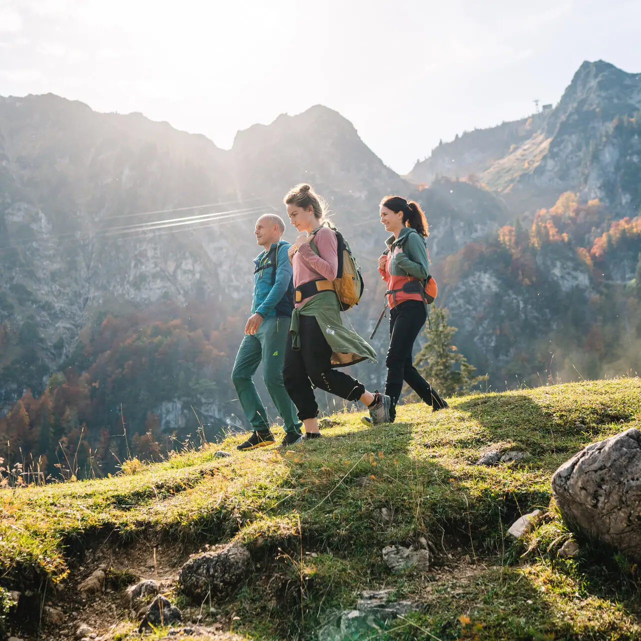 Hiking in Ruhpolding A group of people are walking on a hill in Ruhpolding, with mountains in the background.