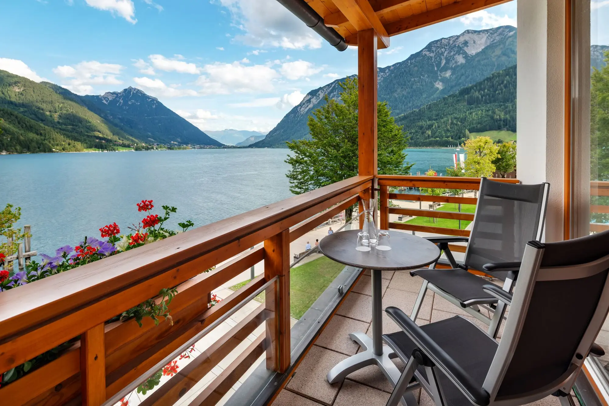 Balcony with table and chairs overlooking a lake.
