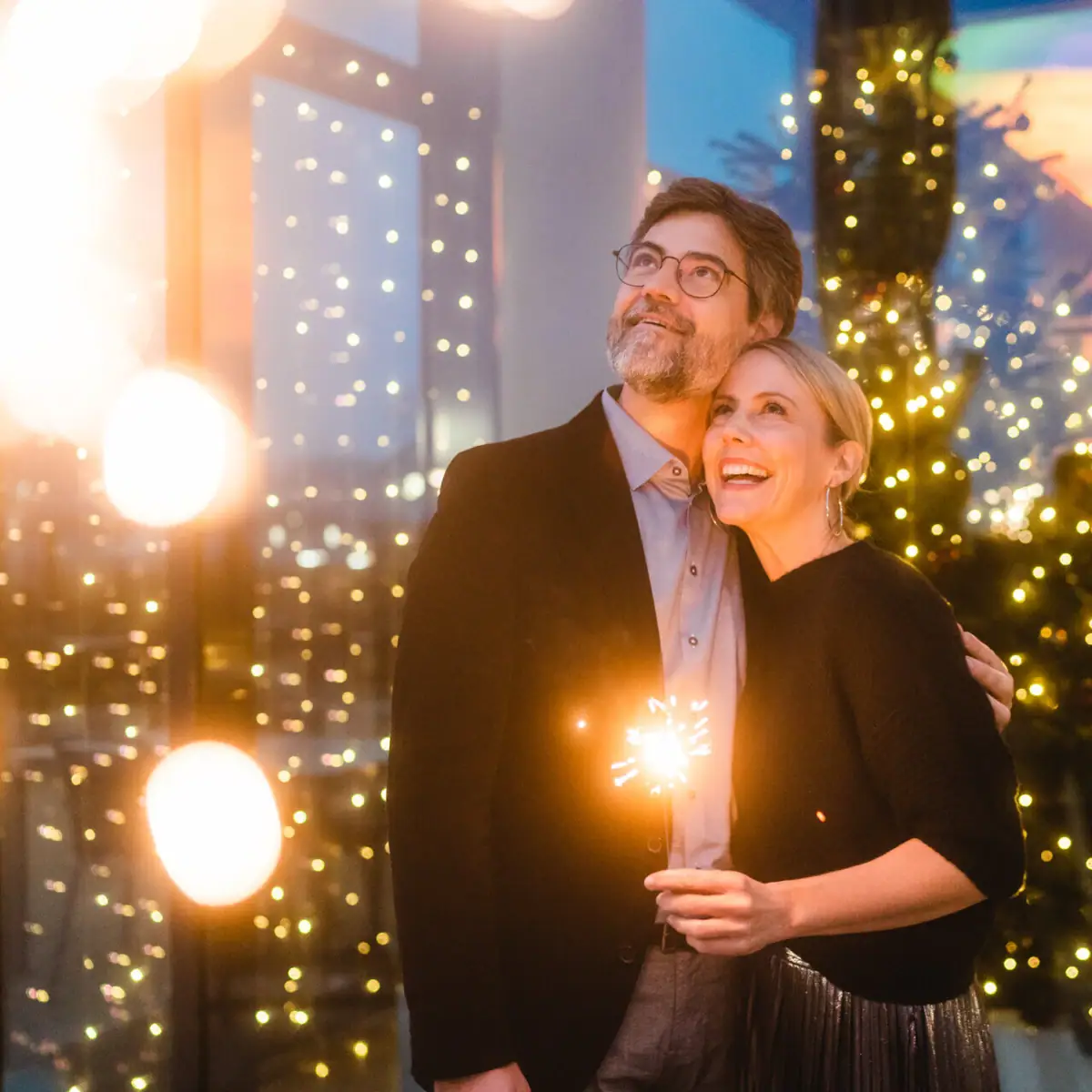 A man and a woman hold sparklers.