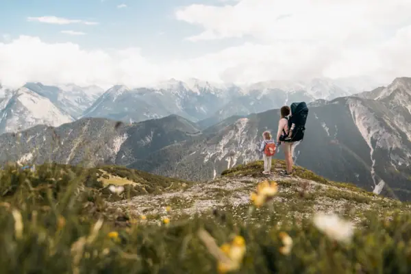 A family on a walk in Bavaria, with mountains in the background.