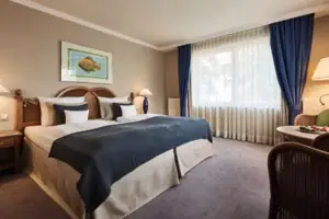 A bedroom with a bed and a lamp.