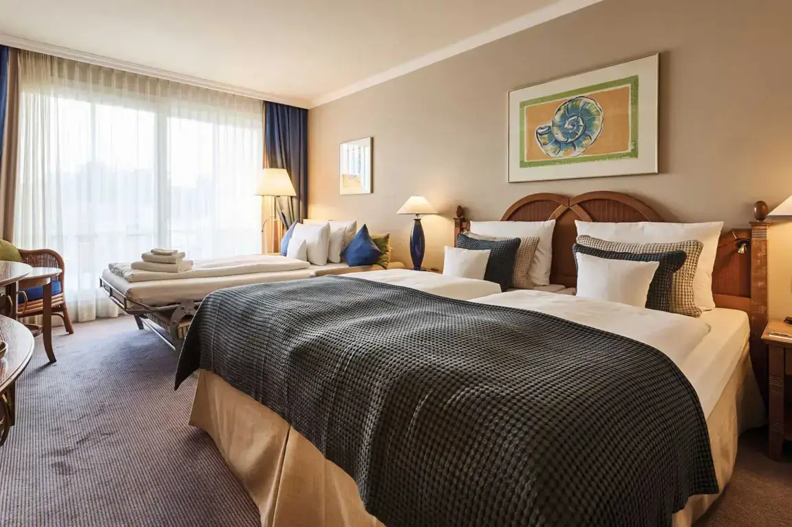 A room with two beds and a large bed.