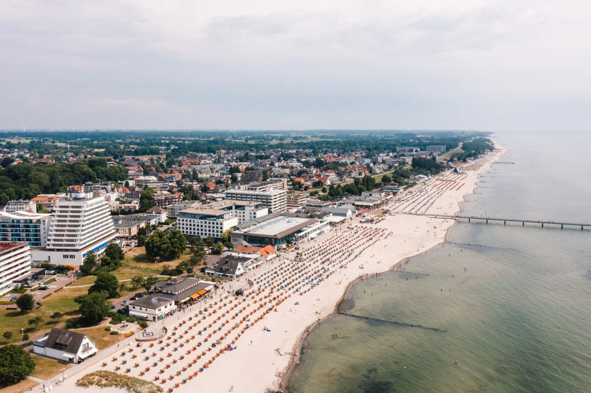aja Grömitz A bird's eye view of the beach with lots of people and buildings.