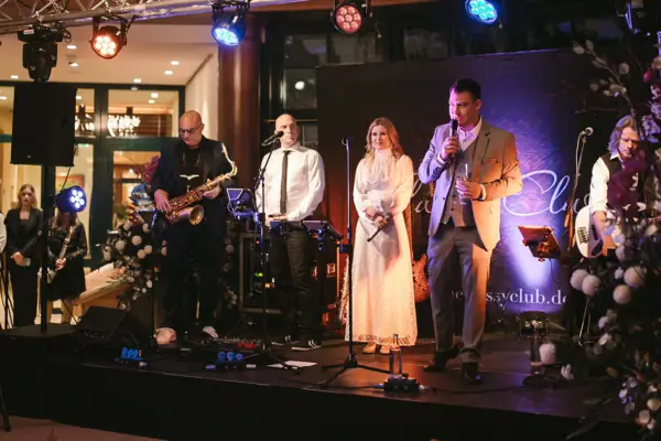 A group of people on a stage at a concert with musical instruments.