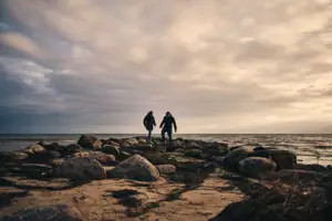 Göhren beach Two people are standing on a rocky beach.