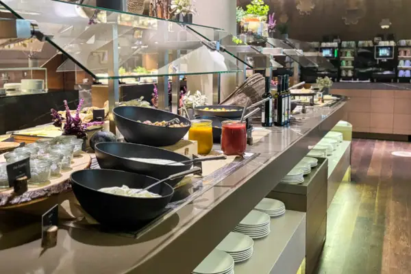 Buffet table with plates and bowls full of food in a restaurant.