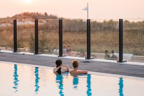 Two people swimming in a pool.