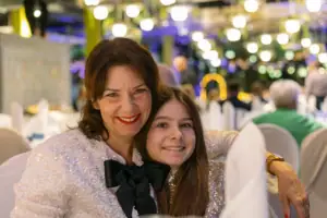 A woman and a girl smile at the camera.