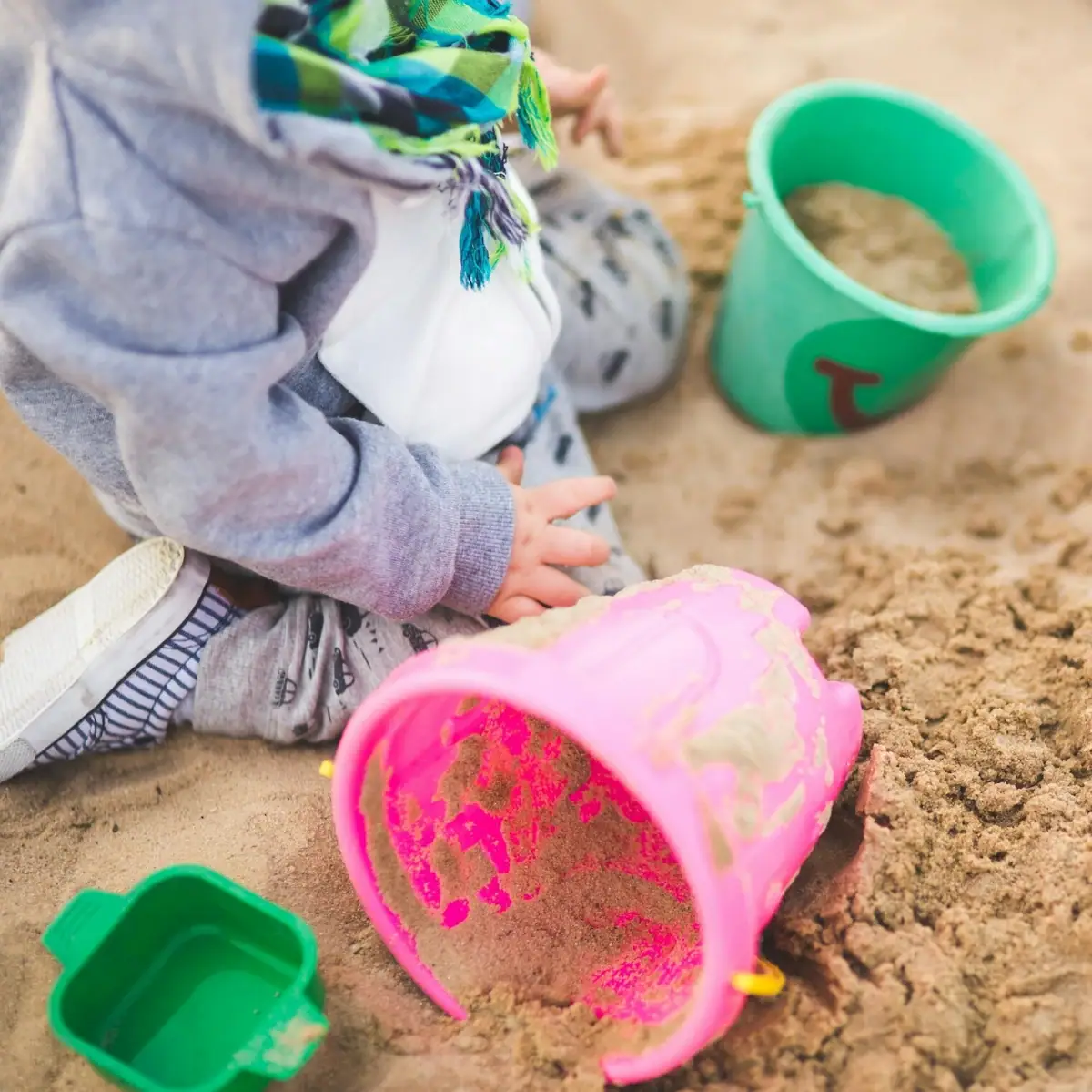 A child plays in the sand.