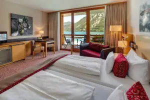 Double room A room with two beds, a table and chairs, view of a lake.