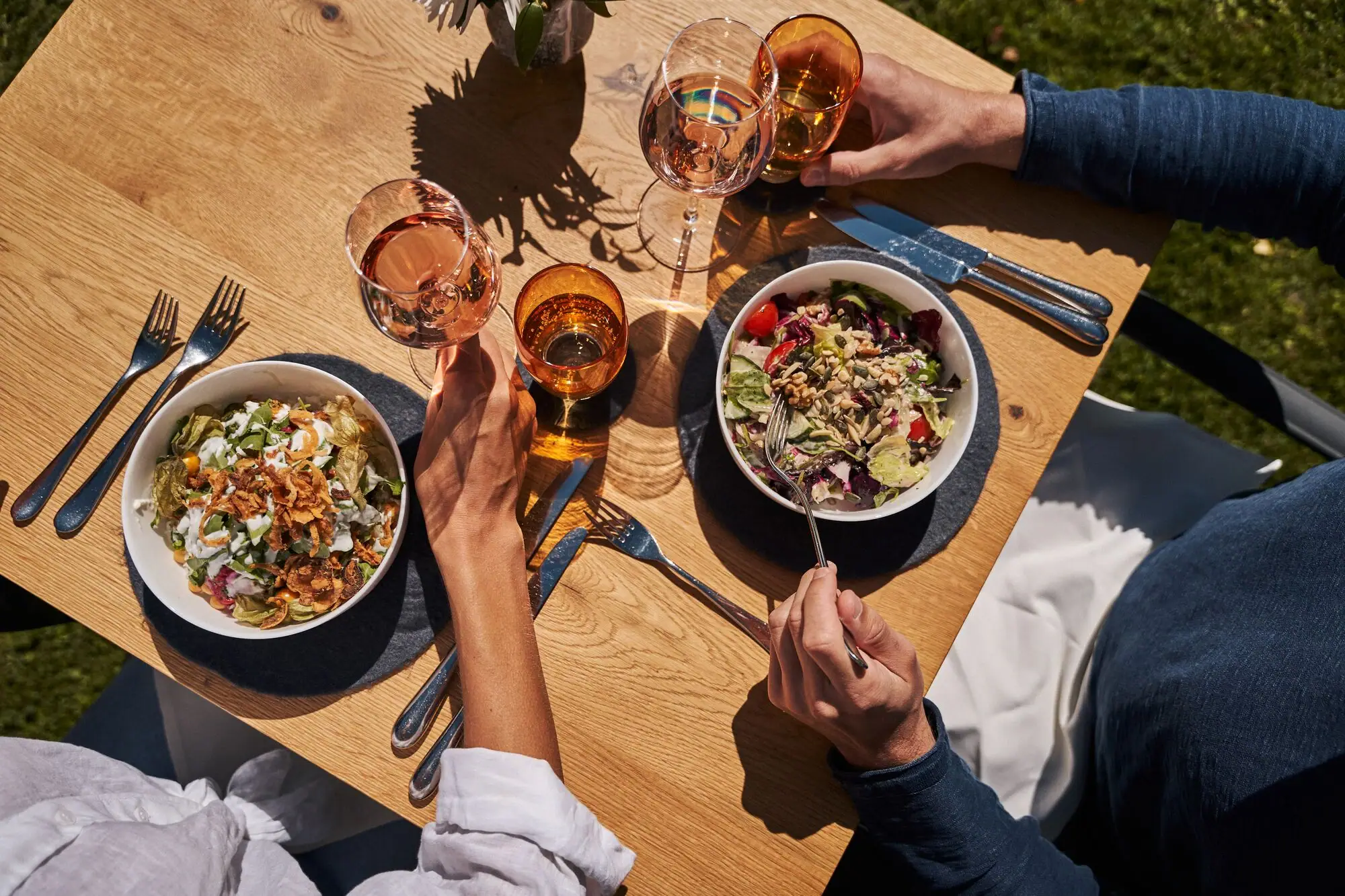 Guest garden A group of people eating at a table with food and drinks.