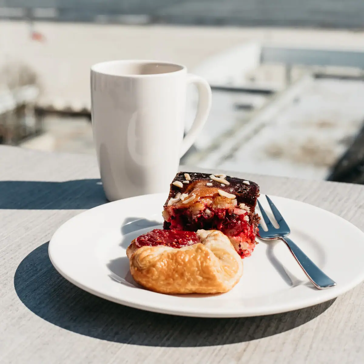 A plate of pastries and a cup of coffee on a table.
