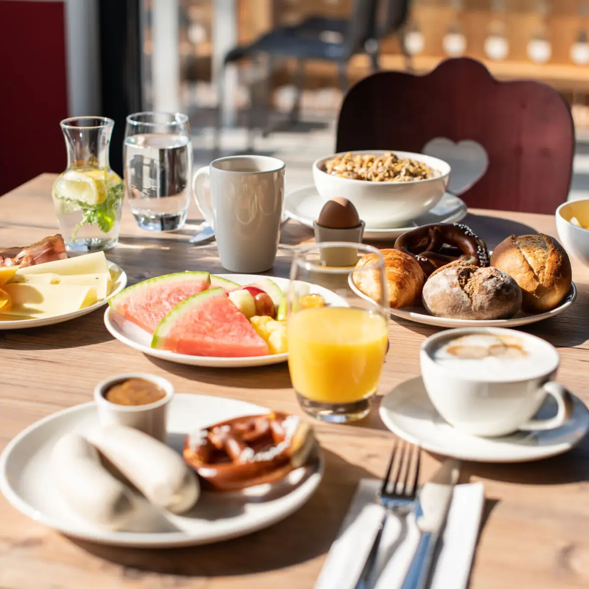 Breakfast at aja Ruhpolding A table with various dishes and crockery.