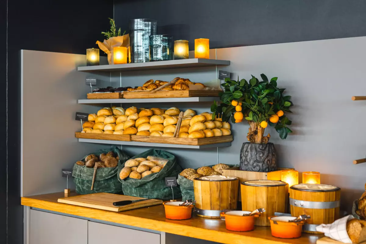 A buffet with bread and oranges on it.