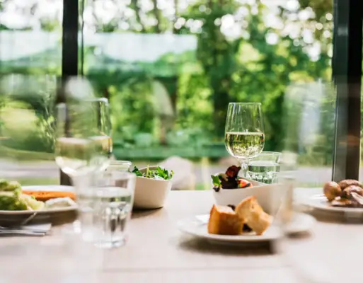 A table with various dishes and wine glasses.
