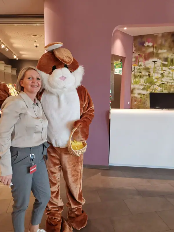 A woman stands next to a person in a piece of clothing.