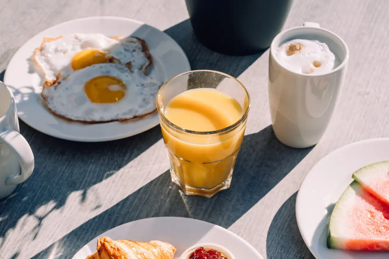 A table with plates full of food and drinks.