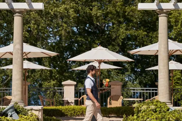 Bar outdoor area A man walks along a path with umbrellas.