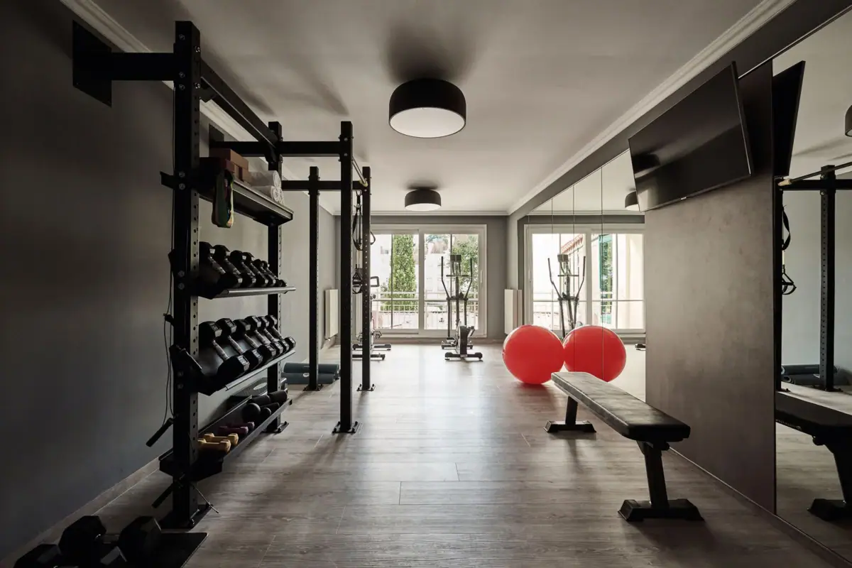 A gym with dumbbells and a bench.
