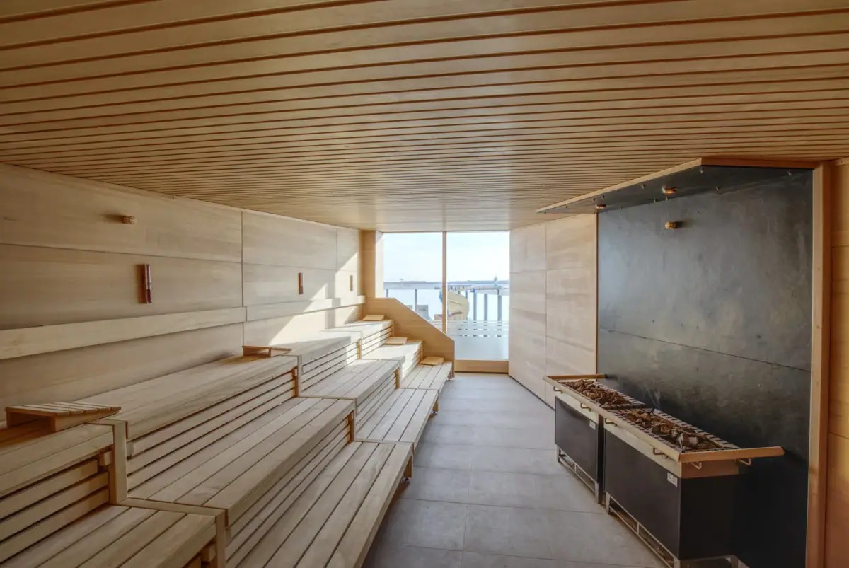 A sauna with wooden benches and a fireplace.