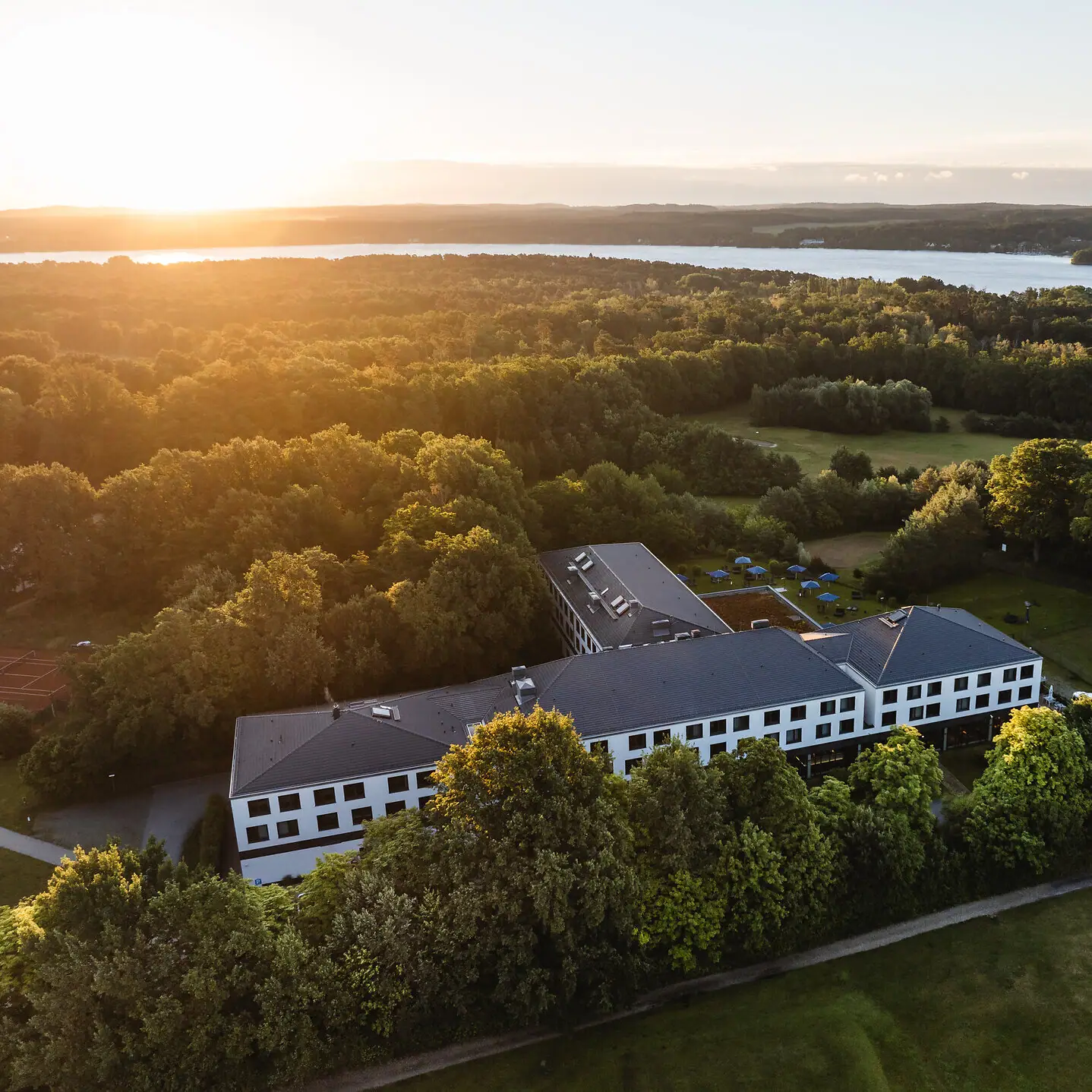 aja Bad Saarow A building surrounded by trees and a body of water.