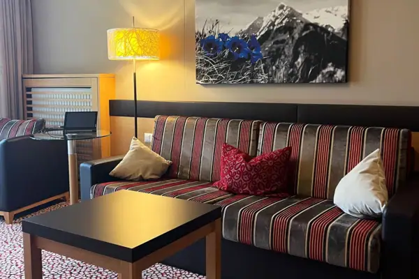 Couch with cushions and a table in one room.