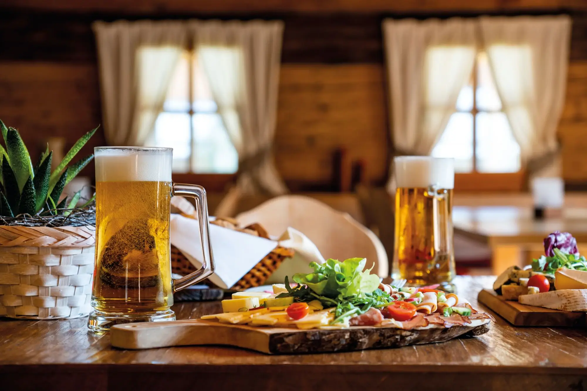 A plate of food and a beer mug on a table.