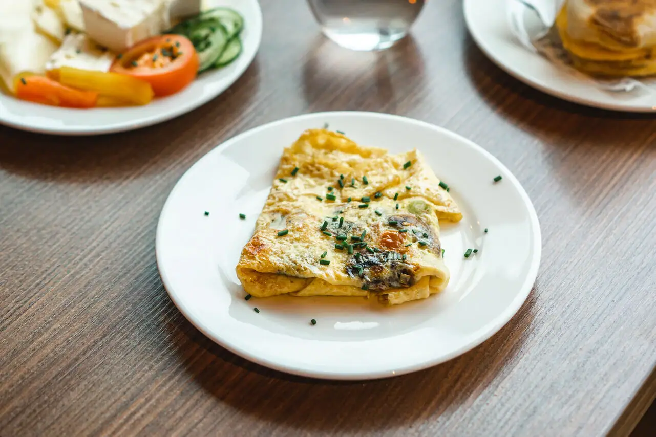 Omelette A table with plates full of food and drinks.