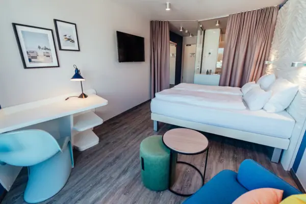 A room with a bed, a table and a chair.