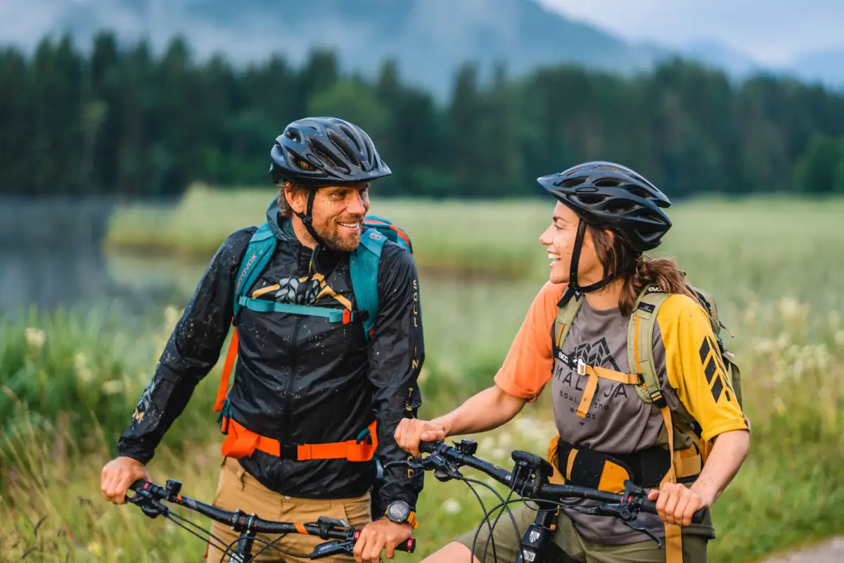 Cycling A man and a woman on a bicycle, both wearing bicycle helmets.
