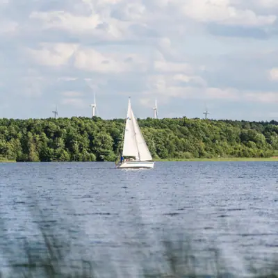 Sailling Sailboat on a lake under a cloudy sky.