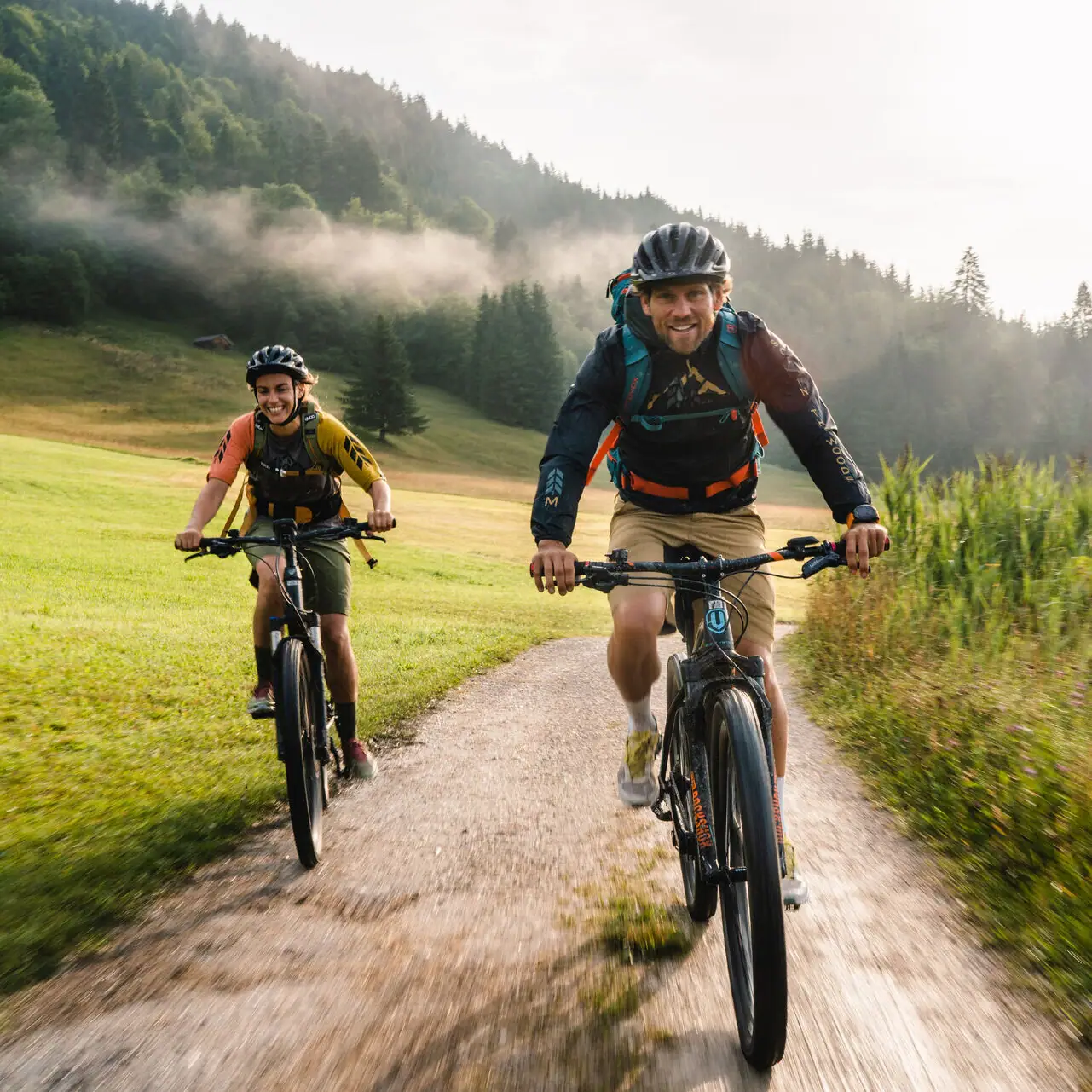 Garmisch cycle paths Two people are riding bicycles on a dirt road.