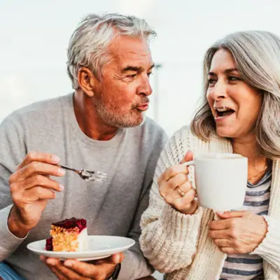A man and a woman eating cake.