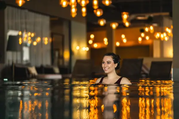 A woman smiles in a pool.