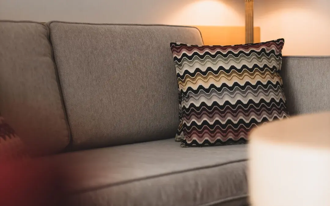 A lamp next to a sofa in a living room.