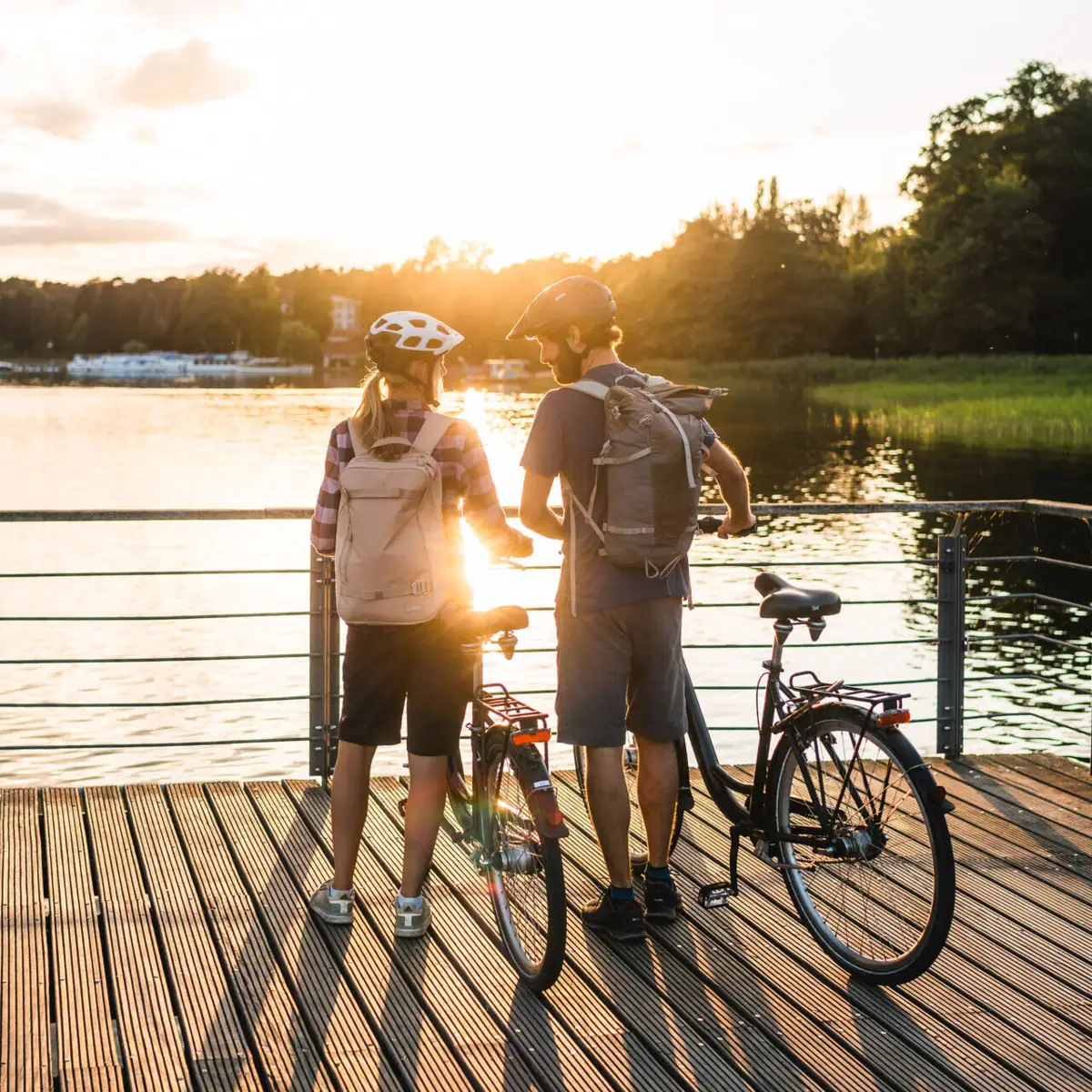 A man and a woman with bicycles on a footbridge.